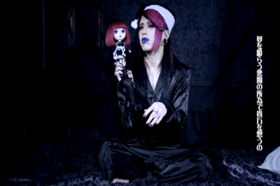 a woman is sitting on a bed holding a doll in her hand .