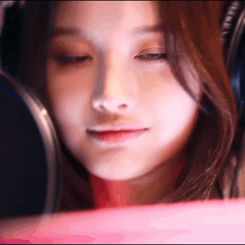 a close up of a woman 's face with her eyes closed and headphones on