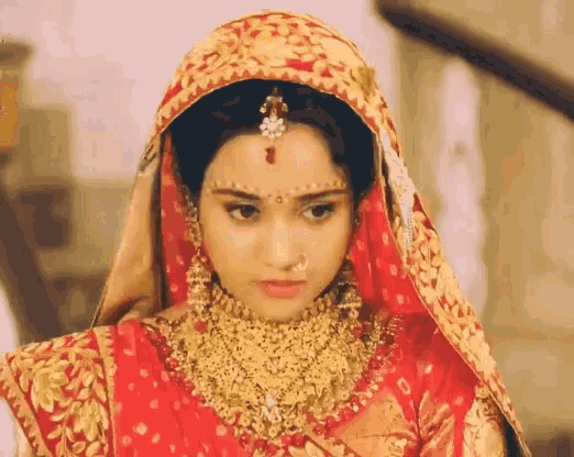 a woman wearing a red and gold dress and veil