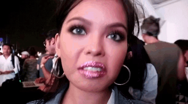 a close up of a woman 's face with pink lipstick on her lips