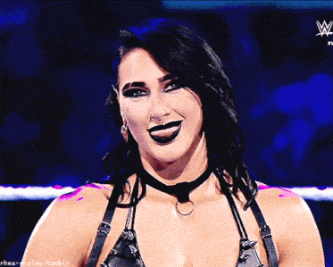 a woman in a wrestling ring with a w logo on the bottom right
