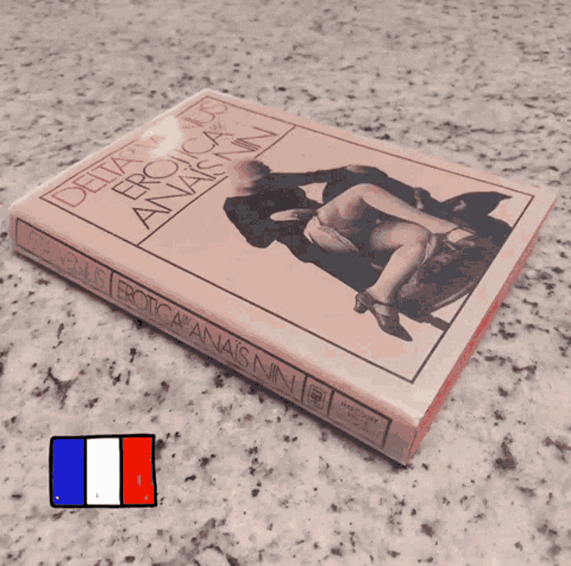 a book titled erotica anaïs nin sits on a marble counter top