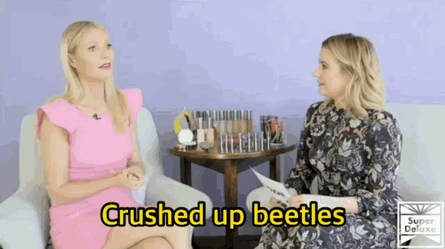 two women are sitting on a couch with the words crushed up beetles in yellow