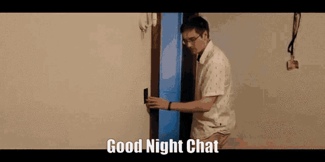 a man is standing in front of a door with the words good night chat written on it .