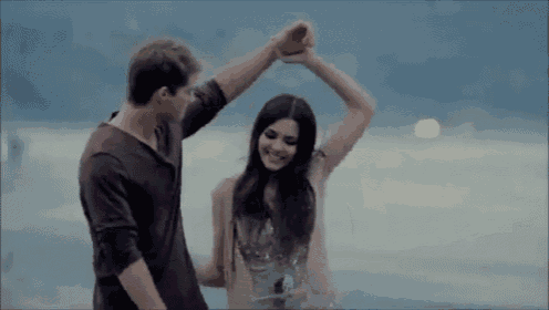a man and a woman are dancing on a beach .