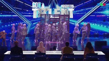 a group of people are dancing in front of a sign that says got talent argentina