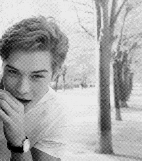 a black and white photo of a young man with his mouth open