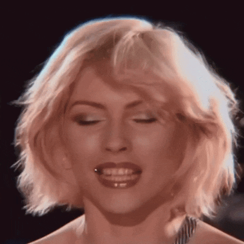 a close up of a woman 's face with her eyes closed and her mouth open