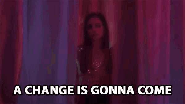 a woman is standing behind a curtain with the words `` a change is gonna come '' written on it .