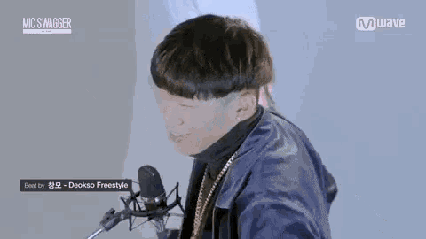 a young man is sitting in front of a microphone and smiling .