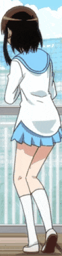 a girl in a blue skirt and white socks is standing on a balcony looking at the ocean .