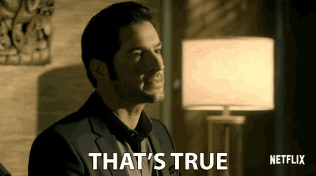 a man in a suit says " that 's true " next to a lamp