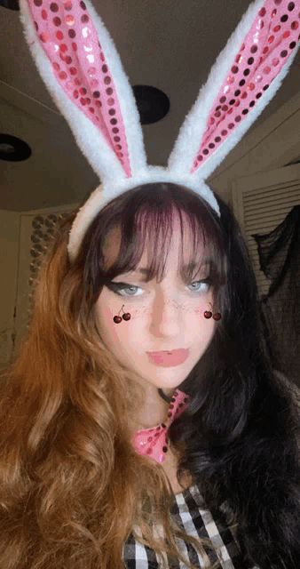 a girl wearing bunny ears and a pink bow