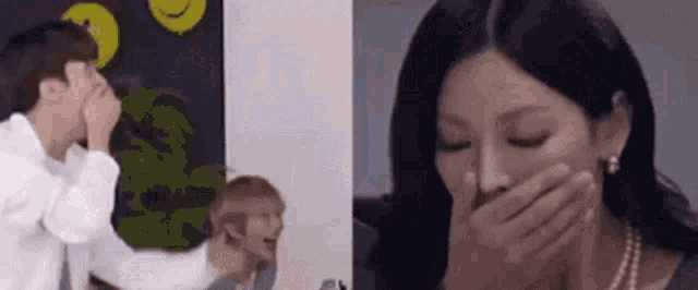 a man and a woman are laughing and the woman is covering her mouth with her hand .