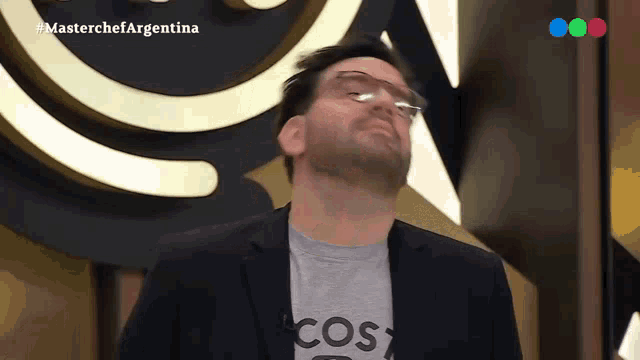 a man wearing glasses and a t-shirt that says cost