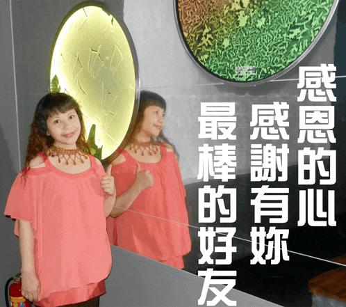 a woman in a pink top is giving a thumbs up in front of a mirror