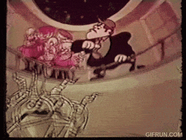 a gif from gifrun.com shows a man in a tuxedo talking to a group of people