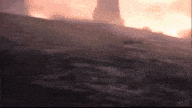 a blurry picture of a person standing on a hill with a sunset in the background .