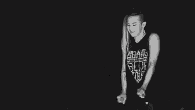 a black and white photo of a man with dreadlocks holding a microphone in his hand .