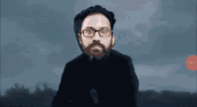 a man with glasses and a beard stands in front of a cloudy sky