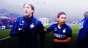 two soccer players are standing on a field and one has the word irelli on his jersey