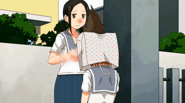 a girl with a bag on her head stands next to a boy