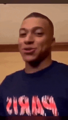 a man wearing a t-shirt that says ' nirvana ' on it makes a funny face