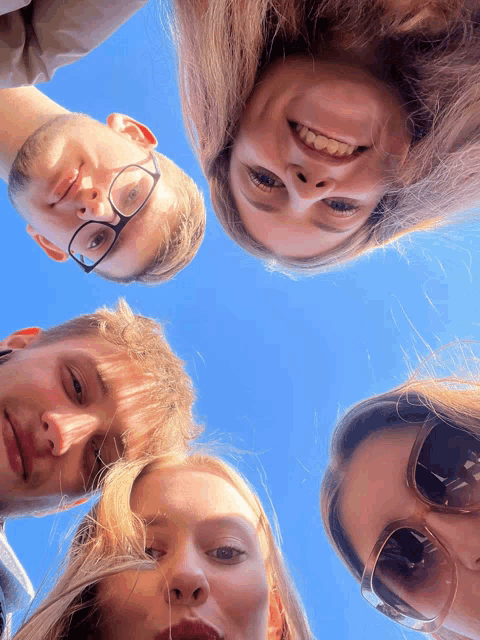 a group of people are looking up at the sky and smiling