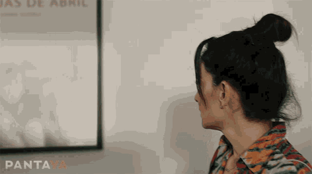 a woman stands in front of a poster that says pantaya on it