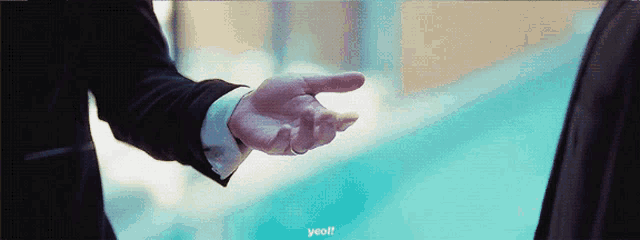 a man in a suit holds out his hand to another man