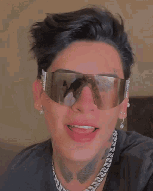 a close up of a person wearing sunglasses with a tattoo on their face