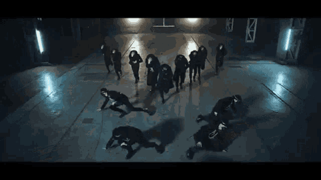 a group of people are dancing together in a dark room