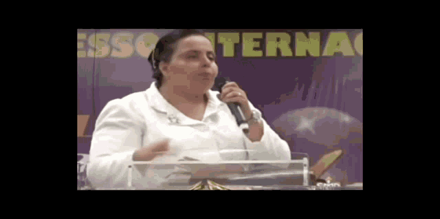 a woman speaking into a microphone in front of a sign that says " terna "