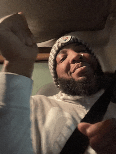 a man with a beard wearing a beanie with the steelers logo on it