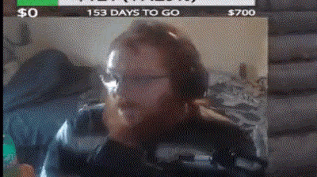 a man with a beard is sitting in front of a computer screen with 153 days to go