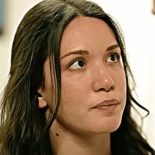 a close up of a woman 's face with her eyes looking up
