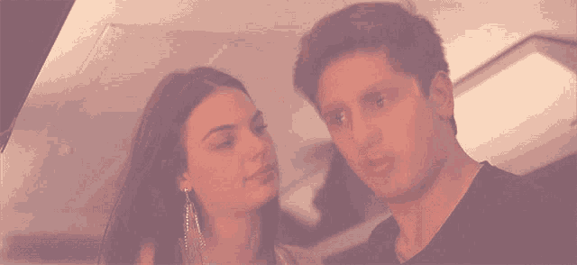 a man and a woman are looking at each other and the man is making a funny face