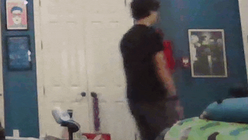 a man is standing in a bedroom in front of a door .