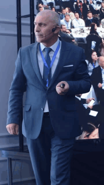 a man in a suit and tie stands in front of a group of people