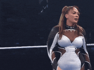 a woman in a wrestling ring with a sign that says mac in the background