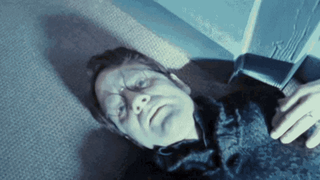 a man is laying on the floor with his eyes closed and his face painted blue
