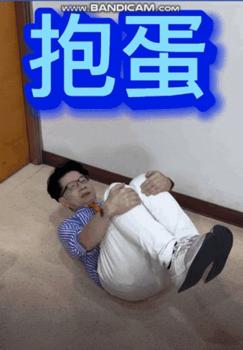 a man is laying on the floor with chinese writing above him