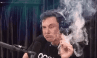 elon musk is smoking a cigarette while wearing headphones and making a face .