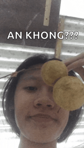 a person holding a potato chip in front of their eye with the caption " an khong " above them