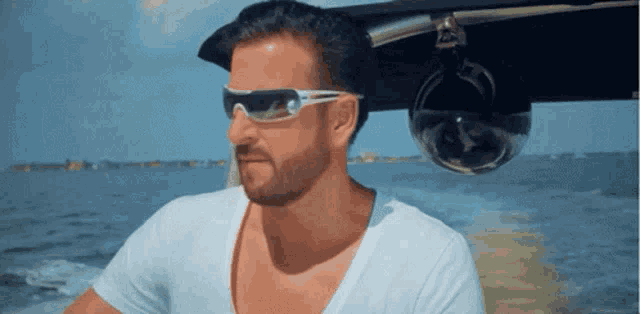 a man wearing sunglasses and a white shirt is sitting on a boat