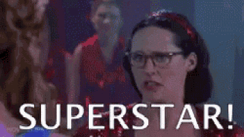 a group of people are dancing on a stage and the words `` superstar '' are written on the screen .