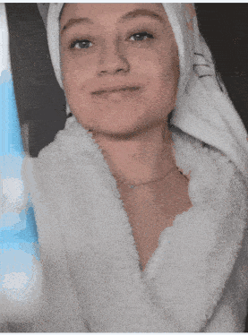 a woman wearing a white robe and a towel on her head