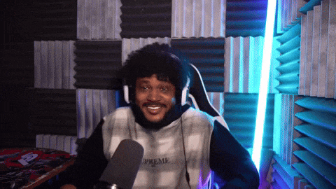 a man wearing headphones and a shirt that says prime is sitting in front of a microphone