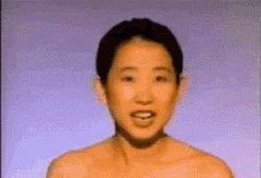 a close up of a woman 's face with a ponytail and a bun .