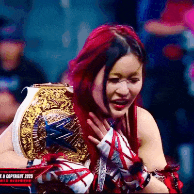 a woman with red hair is holding a gold and white wrestling ring